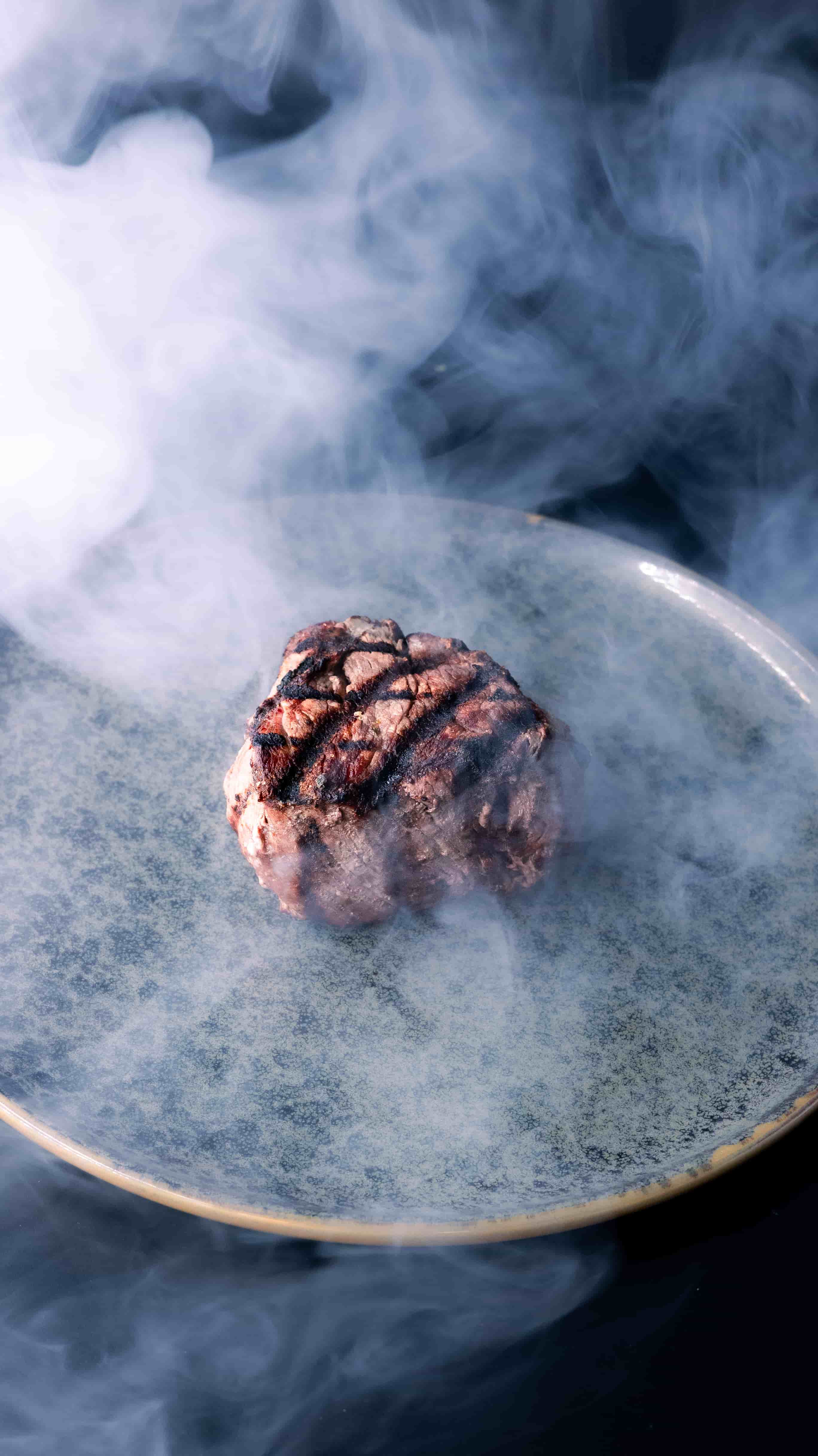 Premium steak grilling with smoke